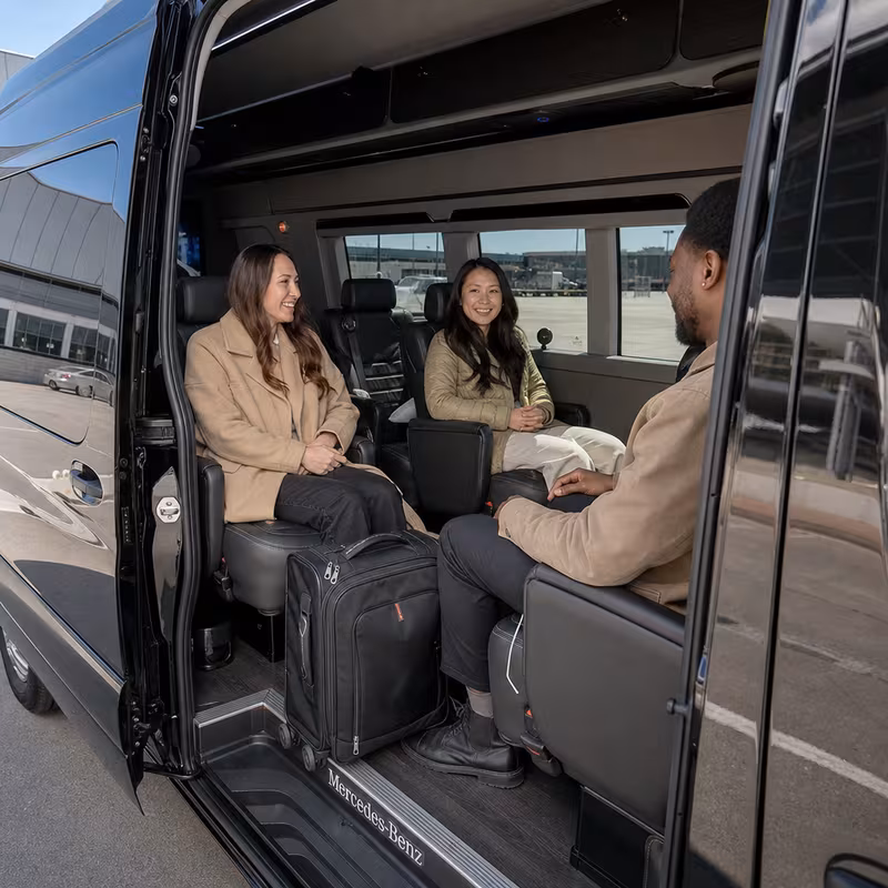 Passengers loading luggage while boarding an Cincinnati group shuttle