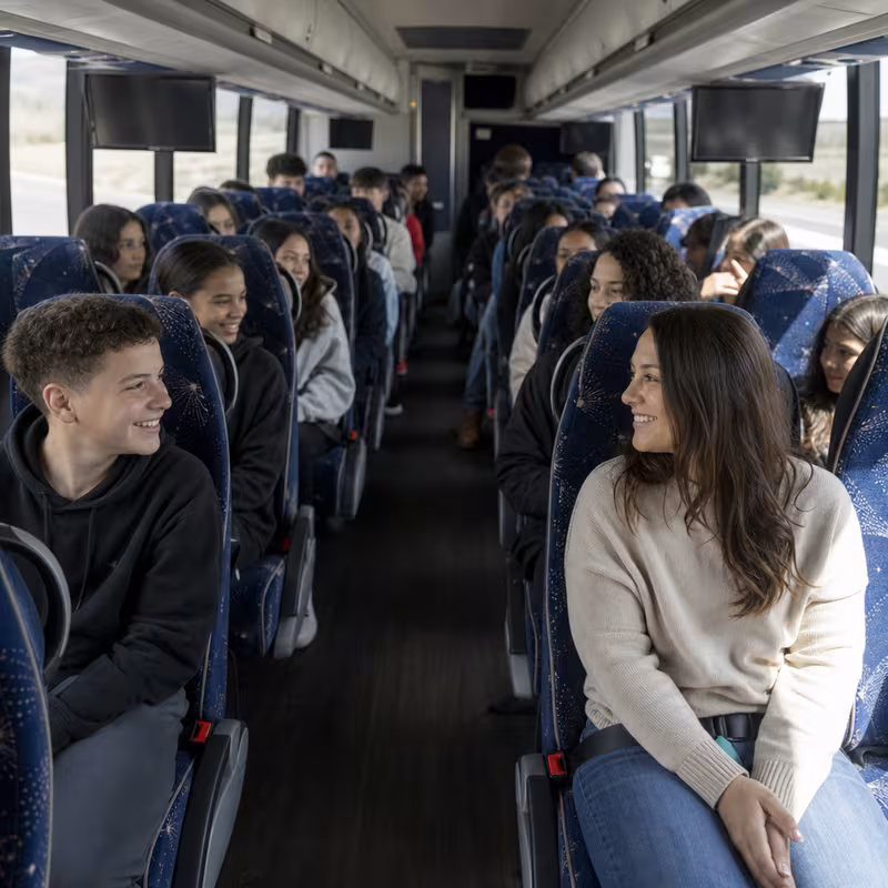 Group boarding a white charter bus for School Transportation transportation in Cincinnati