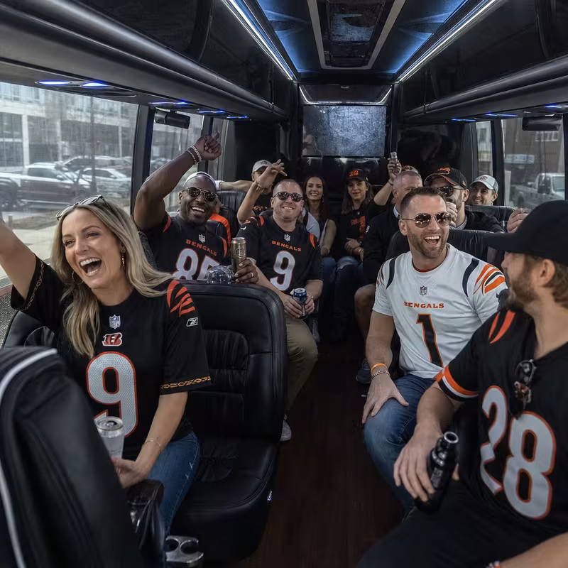 Group boarding a white charter bus for Sporting Event Transportation transportation in Cincinnati